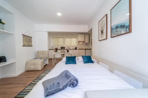 ein Schlafzimmer mit einem großen weißen Bett mit blauen Kissen in der Unterkunft Praça Velha I in Braga