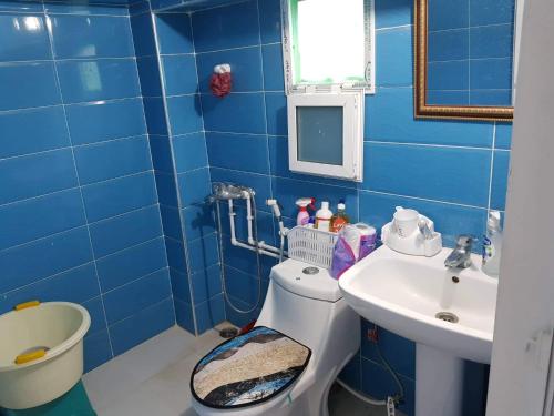 bagno blu con servizi igienici e lavandino di Cirta duplexe a Qusanṭīna (Costantina)