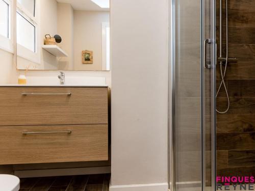 uma casa de banho com um chuveiro e uma gaveta de madeira em Algues apt 8 em Platja d'Aro