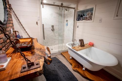 a bathroom with a tub and a shower and a sink at The Hobbit House, Fantasy comes Home! in Russellville