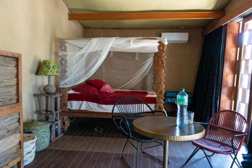 - une petite chambre avec un lit, une table et des chaises dans l'établissement Maison Etoile, à Dakar