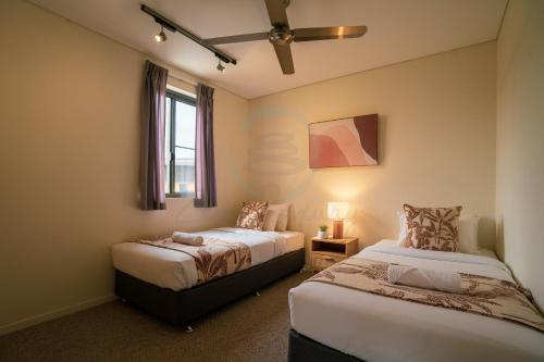 a bedroom with two beds and a window at ZEN PARADISE - 2-BR Waterfront Ocean View Retreat in Darwin