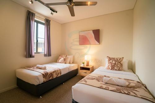 a bedroom with two beds and a window at ZEN PARADISE - 2-BR Waterfront Ocean View Retreat in Darwin