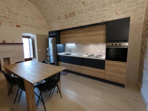 a kitchen with a wooden table and a large kitchen at La casa di pietra in Monopoli