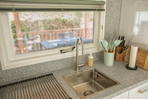 a kitchen counter with a sink and a window at ThuizInOuddorp Parel no 30 & Oester no 29 Verkoeling aan Zee in Ouddorp