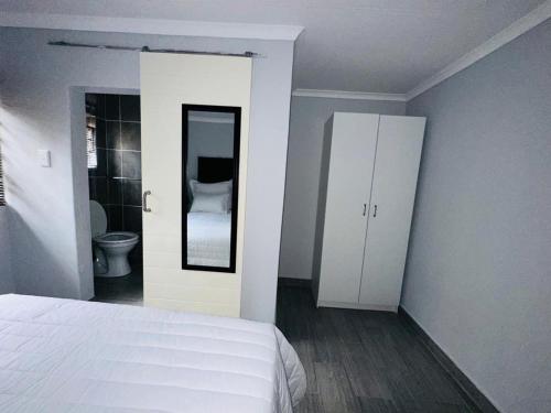 a bedroom with a bed and a bathroom with a toilet at The Curve Apartments Unit 5 in Johannesburg
