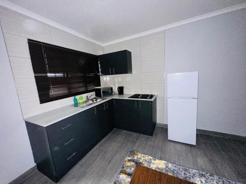 una cucina con armadi verdi e frigorifero bianco di The Curve Apartments Unit 5 a Johannesburg