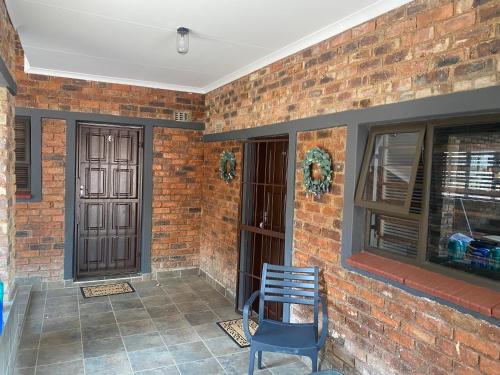 una sedia blu seduta su un patio con muro di mattoni di The Curve Apartments Unit 5 a Johannesburg