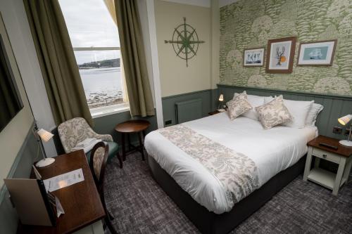 a hotel room with a bed and a window at Ardencaple Hotel by Greene King Inns in Rhu