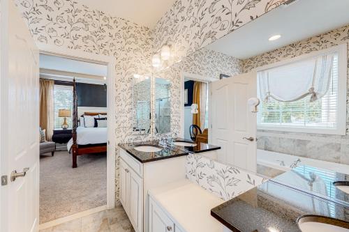 a bathroom with two sinks and a tub and a bedroom at Millville by the Sea --- 39008 Seascape Ct in Millville