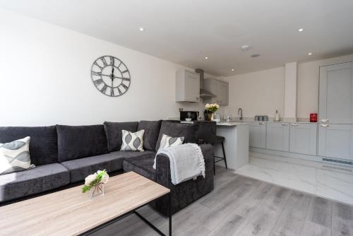 a living room with a couch and a table and a kitchen at Bishops Lynn House Apartments - Town Centre in Kings Lynn