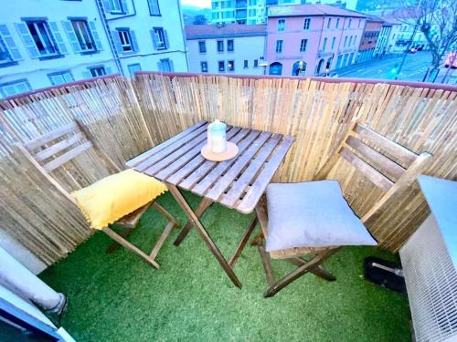 a picnic table and two chairs on a balcony at Loft66 avec parking privé in Clermont-Ferrand
