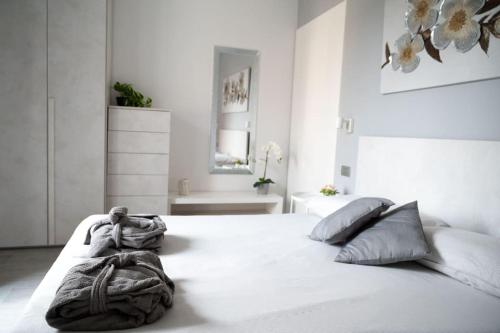 a white bedroom with a large white bed with pillows at A Casa di Patty 2 in Gorgonzola