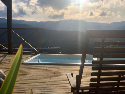 a chair sitting on a deck next to a swimming pool at Cabanas Recanto do Rancho - Rancho Queimado in Rancho Queimado