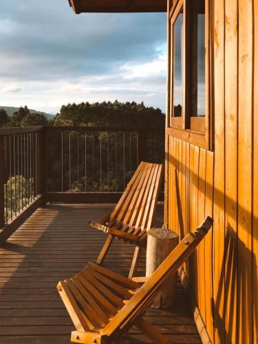 a wooden bench sitting on the deck of a house at Cabanas Recanto do Rancho - Rancho Queimado in Rancho Queimado