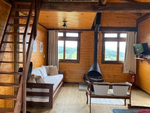 a log cabin with a bed and a fireplace at Cabanas Recanto do Rancho - Rancho Queimado in Rancho Queimado