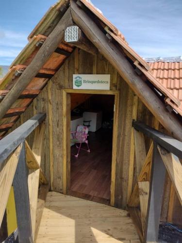 a wooden house with a roof with a doorway at Cabanas Recanto do Rancho - Rancho Queimado in Rancho Queimado