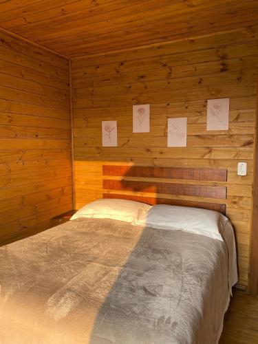 a bedroom with a bed in a wooden cabin at Cabanas Recanto do Rancho - Rancho Queimado in Rancho Queimado