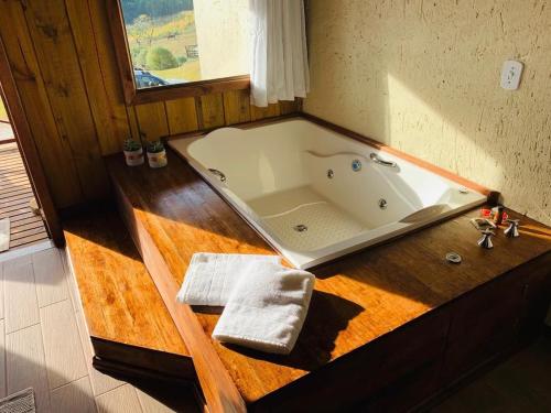 a bathroom with a bath tub on a wooden counter at Cabanas Recanto do Rancho - Rancho Queimado in Rancho Queimado