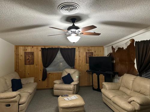 un soggiorno con divani e ventilatore a soffitto di Country Cabins Hotel a Chariton