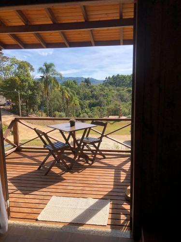 a picnic table on a porch with a view at Cabanas Recanto do Rancho - Rancho Queimado in Rancho Queimado