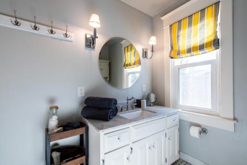 a bathroom with a sink and a mirror at Luxe Highlands Home! King BR~Fire Pit~Yard Games in Louisville
