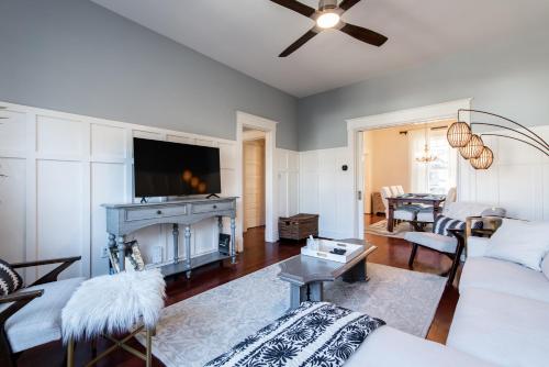 a living room with a white couch and a tv at Luxe Highlands Home! King BR~Fire Pit~Yard Games in Louisville