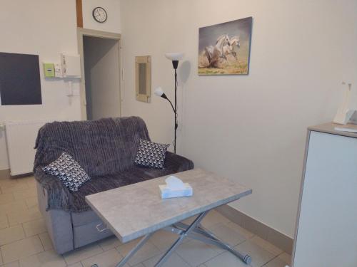 a living room with a couch and a table at Appartement RDC chez Caroline in Bourbonne-les-Bains