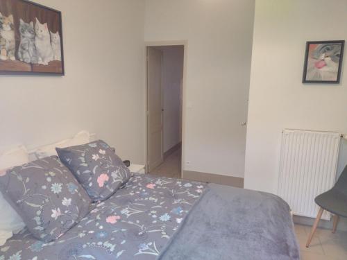 a bedroom with a bed with two pillows on it at Appartement RDC chez Caroline in Bourbonne-les-Bains