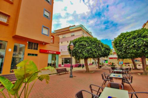 a city street with tables and chairs and trees at Isabel - modern apartment in the center of Moraira in Moraira