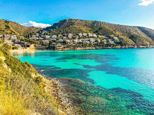 a view of a beach with houses on a hill at Isabel - modern apartment in the center of Moraira in Moraira