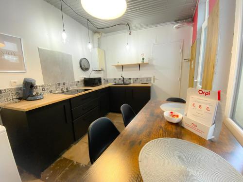 a room with a table and chairs and a kitchen at Le Worker 2 in Calais