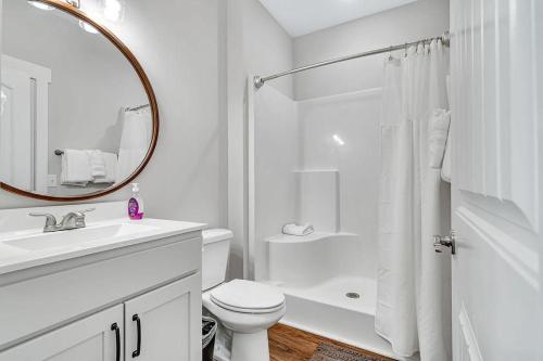 bagno bianco con servizi igienici, lavandino e specchio di SunDaze a Branson