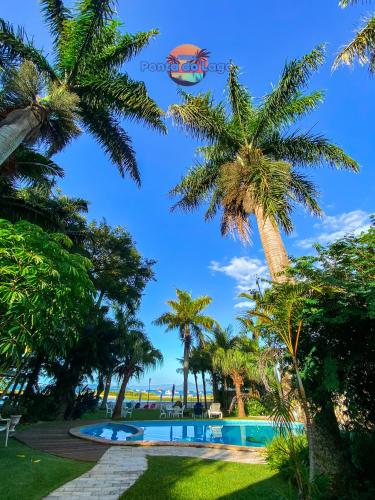 a resort with a swimming pool and palm trees at Pousada Ponta do Lago in Florianópolis