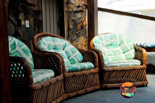 three wicker chairs sitting on a porch at Pousada Ponta do Lago in Florianópolis