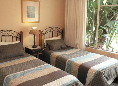 ニューカッスルにあるHouse Ebony B&Bのベッド2台と窓が備わるホテルルームです。
