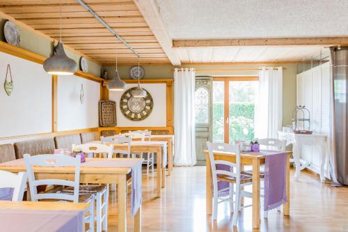 un restaurante con mesas y sillas y un reloj en la pared en Gästehaus Chalet-Perle, en Bad Füssing