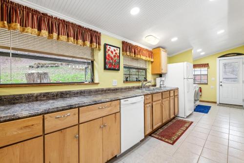 a large kitchen with wooden cabinets and a window at Hidden Creek Cabin in Franklin