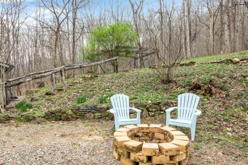 two white chairs sitting next to a fire pit at Hidden Creek Cabin in Franklin