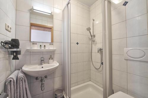 a white bathroom with a shower and a sink at Xeis NeSt in Admont