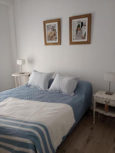 1 dormitorio con 1 cama con 2 cuadros en la pared en Arte y Música en Buenos Aires