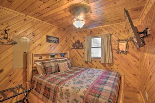 - une chambre avec un lit dans une cabane en bois dans l'établissement Helen Cabin with Deck and Hot Tub Less Than half Mi to Main St, à Helen