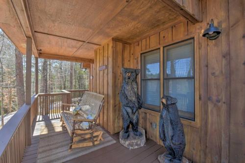 a cabin with two bear statues on the porch at Helen Cabin with Deck and Hot Tub Less Than half Mi to Main St in Helen