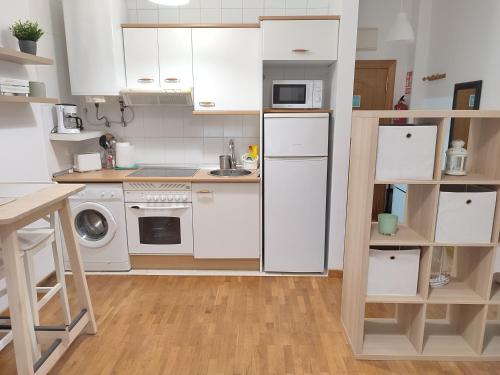 a small kitchen with white cabinets and a sink at LOFT MONTECERRAO H GARAJE Y WiFi GRATIS in Oviedo