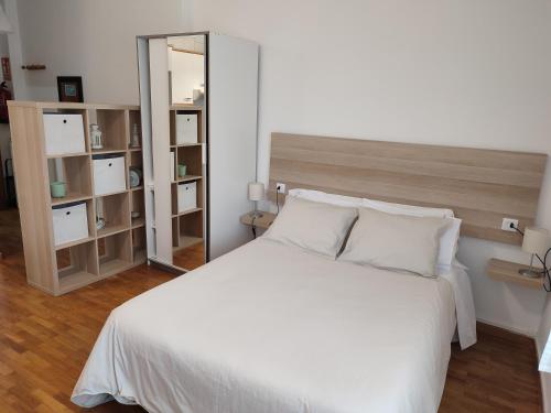 um quarto com uma cama branca e um espelho em LOFT MONTECERRAO H GARAJE Y WiFi GRATIS em Oviedo