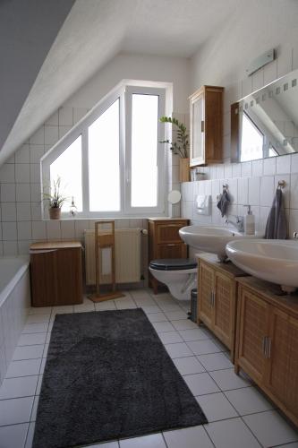 ein großes Badezimmer mit zwei Waschbecken, einer Badewanne und einem Waschbecken in der Unterkunft Ferienwohnung mit Charme in Bad Salzschlirf
