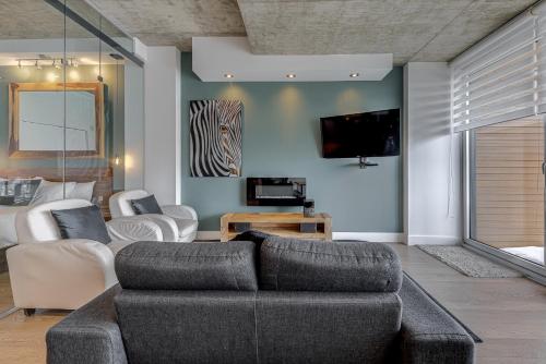 a living room with a couch and a tv at Les Immeubles Charlevoix - Le 760-631 in Quebec City