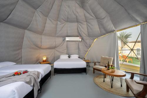 a room with two beds and a tent at Camp Sahara in Kalia