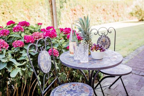 a table with two chairs and a table with flowers at Gästehaus Chalet-Perle in Bad Füssing