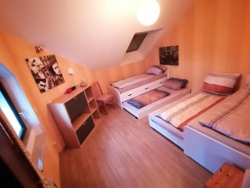 Zimmer im Dachgeschoss mit 2 Betten und einem TV in der Unterkunft Ferienwohnung mit Charme in Bad Salzschlirf
